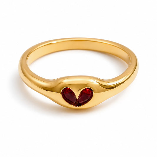 Meinara Bella ring in 18k gold plated stainless steel featuring a sculpted band and a red heart-shaped stone.