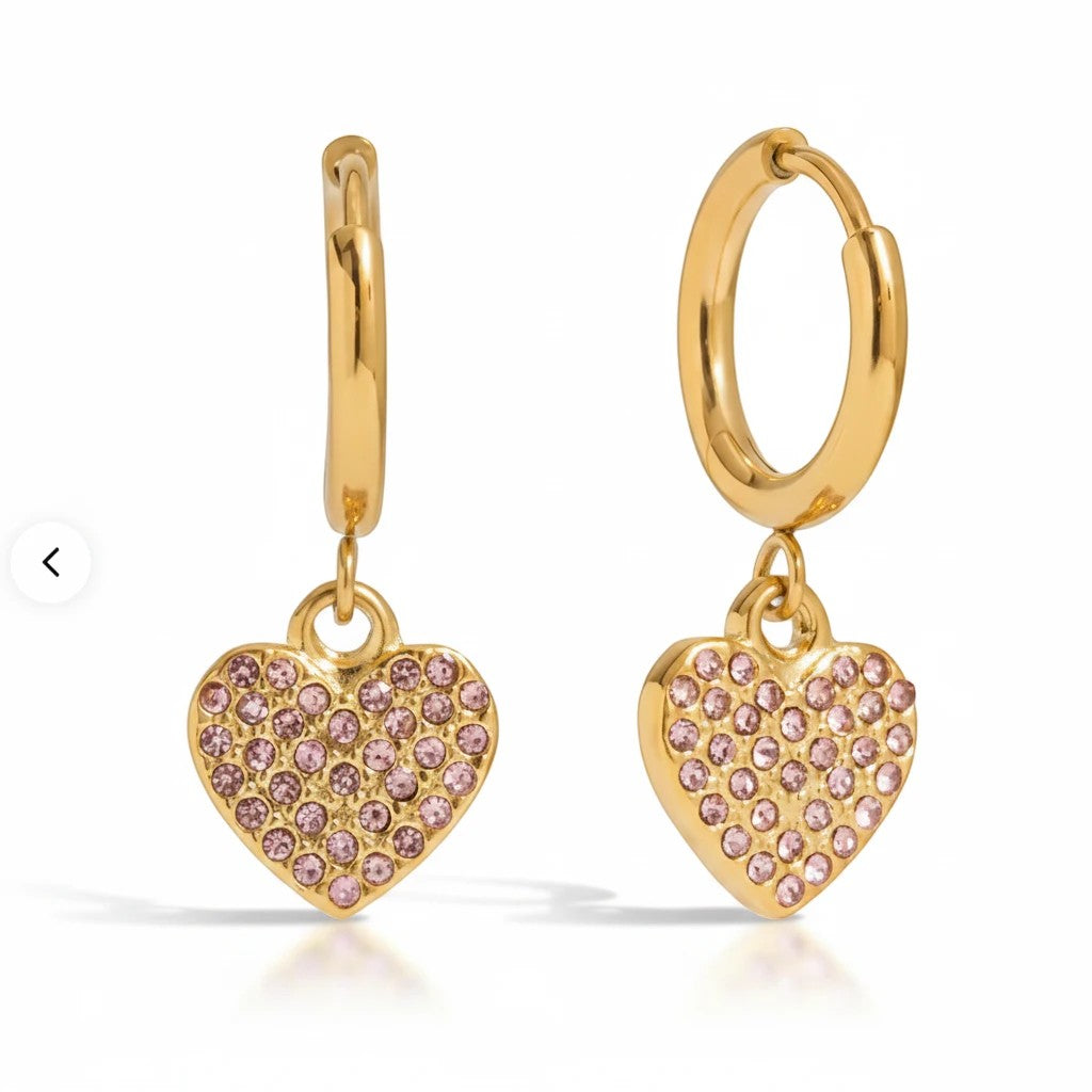 Meinara Nova hoop earrings in gold featuring dangling heart-shaped charms encrusted with small pink crystals