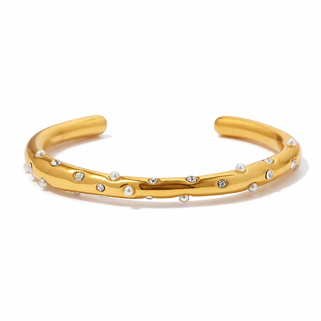 Meinara Solis bangle in gold featuring scattered small white pearls and clear crystal accents on a smooth band