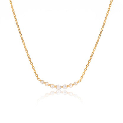 Meinara Venya necklace featuring a delicate gold chain with a curved row of seven sparkling white cubic zirconia stones