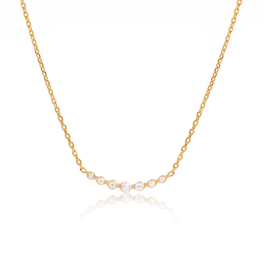 Meinara Venya necklace featuring a delicate gold chain with a curved row of seven sparkling white cubic zirconia stones